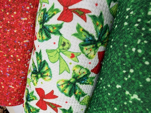 Photographed Christmas bow print fabric with red and green glitter rolls