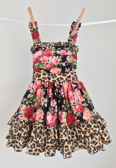 Handmade girls ruffle dress on a clothesline sewn from rose floral and leopard print quilting cotton
